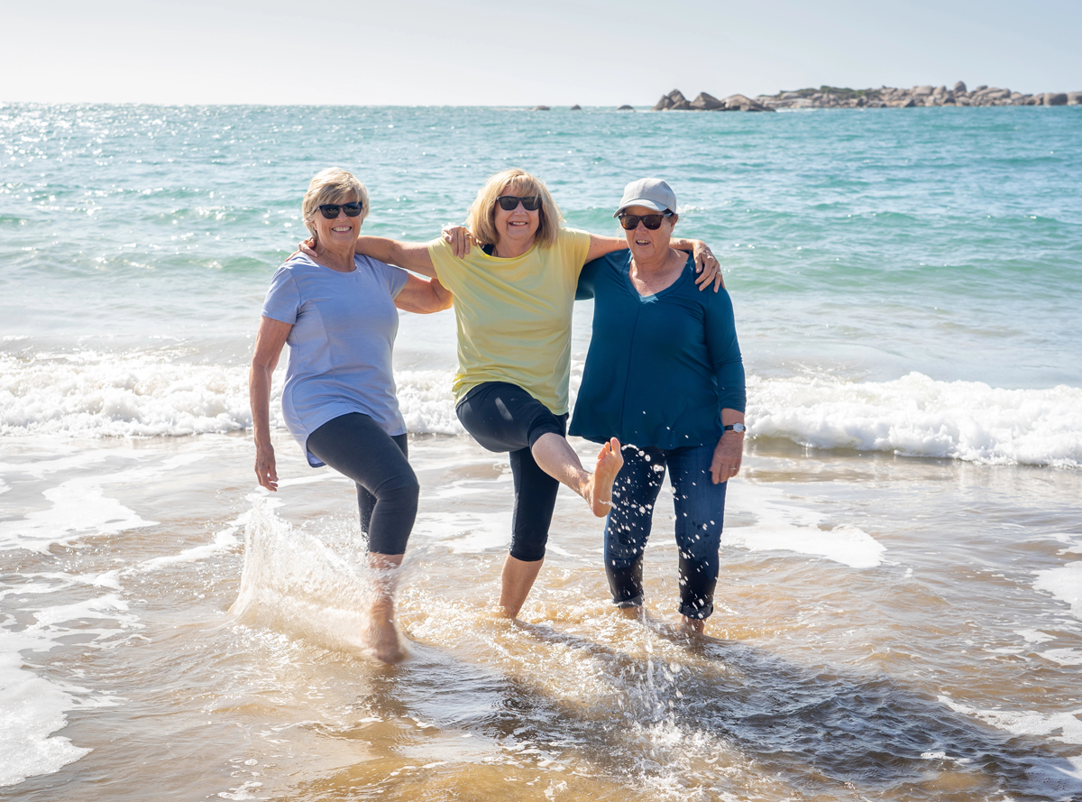 women wading in the ocean